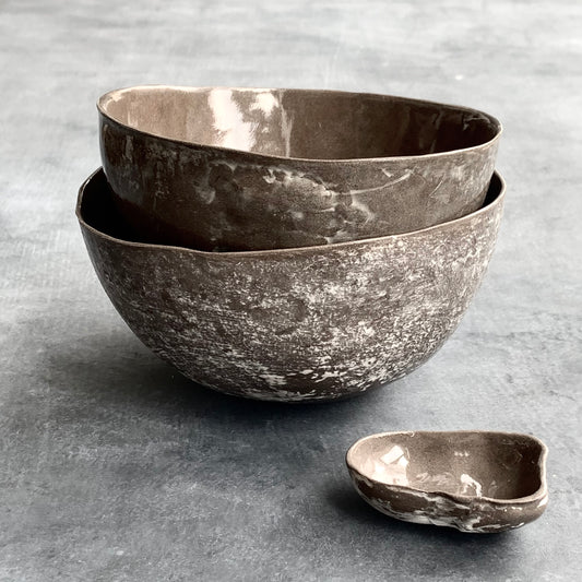 Unique handmade grey-brown ceramic bowl from the Amazon collection. This large bowl made of grey-brown clay enriches your table setting with a rich earthy feel or will surprise someone as a personal ceramic gift. A one of a kind signature piece of tableware with a unique design and white porcelain slib