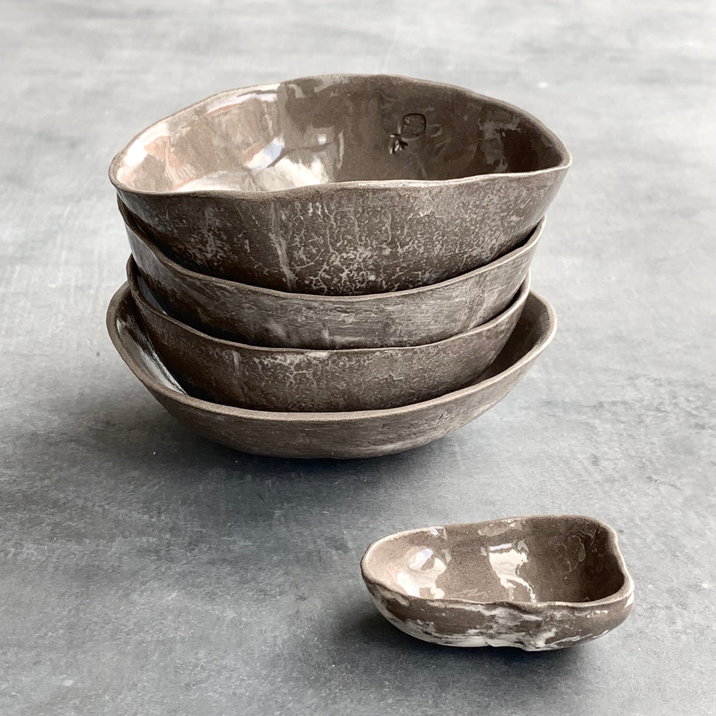 Unique handmade grey-brown ceramic bowl from the Amazon collection. This small bowl made of grey-brown clay enriches your table setting with a rich earthy feel or will surprise someone as a personal ceramic gift. A one of a kind signature piece of tableware with a unique design and white porcelain slib