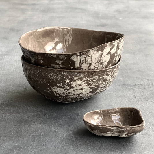 Unique handmade grey-brown ceramic bowl from the Amazon collection. This medium bowl made of grey-brown clay enriches your table setting with a rich earthy feel or will surprise someone as a personal ceramic gift. A one of a kind signature piece of tableware with a unique design and white porcelain slib