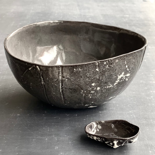 Unique handmade black ceramic bowl from the Amazon collection. This extra large bowl made of black clay enriches your table setting with a mysterious magical feel or will surprise someone as a personal ceramic gift. A one of a kind signature piece of tableware with a unique design and white porcelain slib.