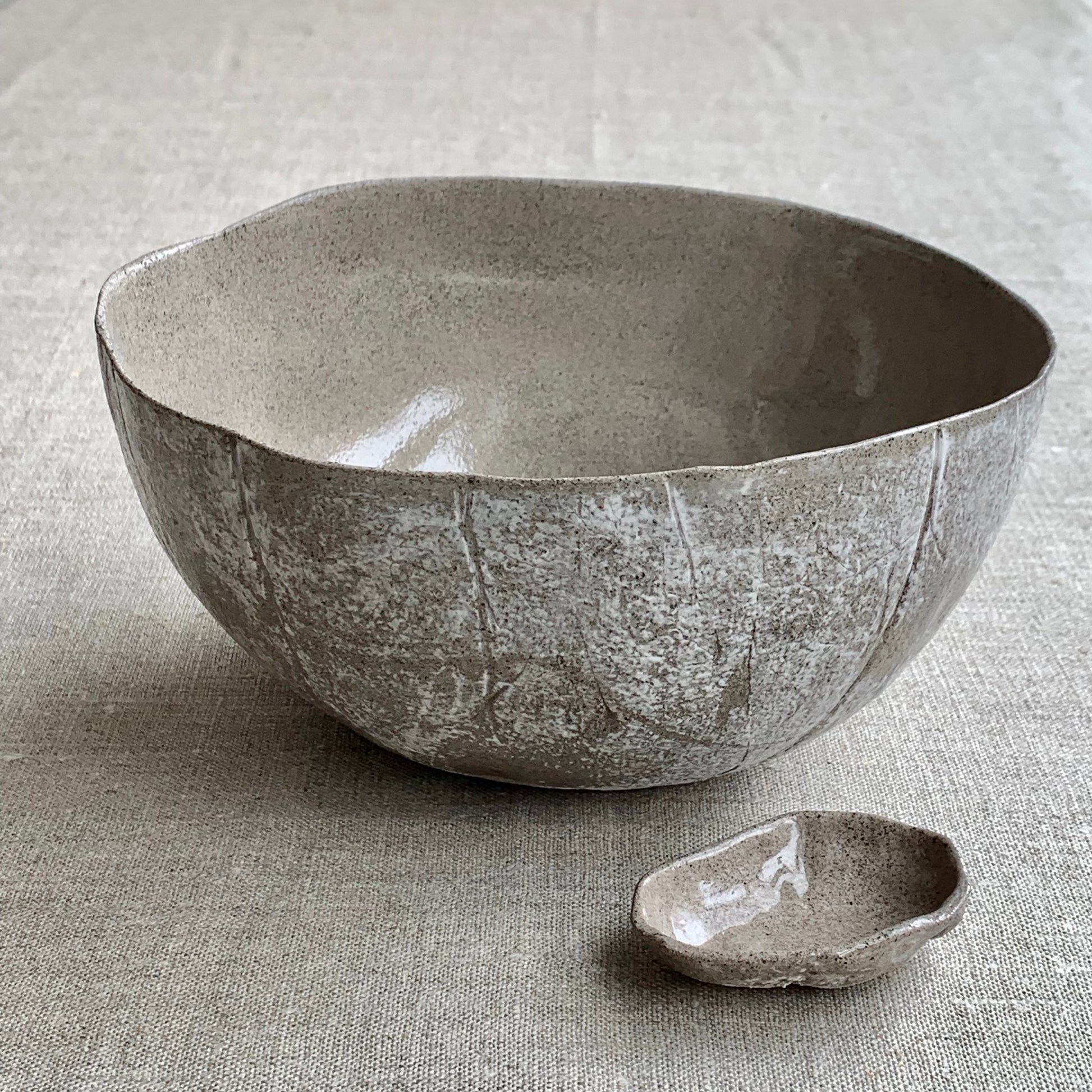 Unique handmade grey ceramic bowl from the Amazon collection. This extra large bowl made of grey clay enriches your table setting with a deep warm feel or will surprise someone as a personal ceramic gift. A one of a kind signature piece of tableware with a unique design and white porcelain slib